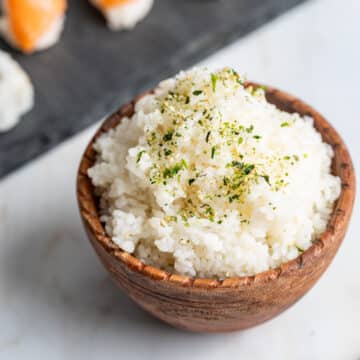 Sushi rice in a wood bowl with furikake seasoning.