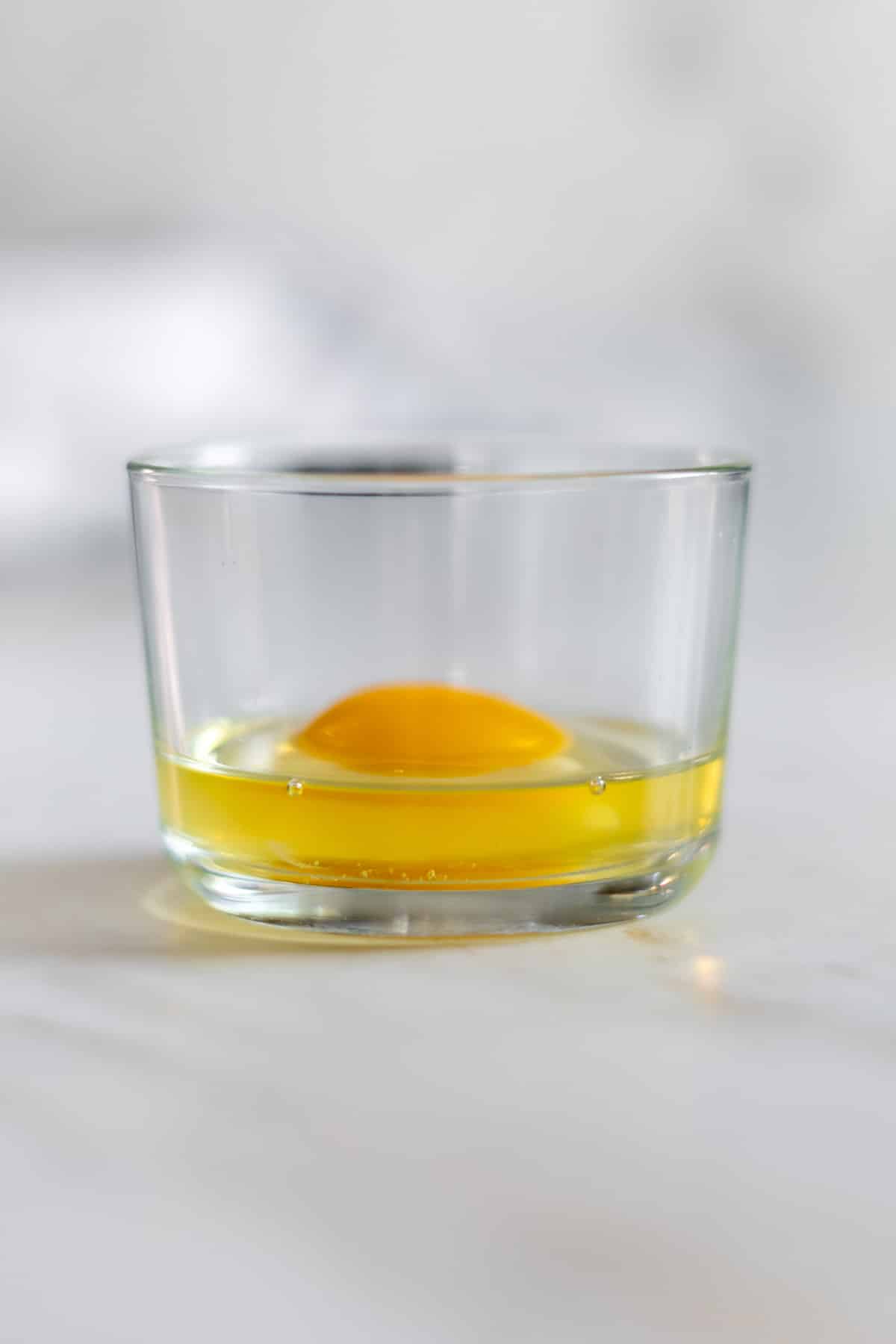 Raw egg in a glass bowl.