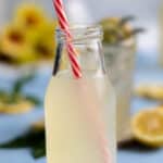 A milk bottle with an Italian lemon soda and a red and white striped straw.