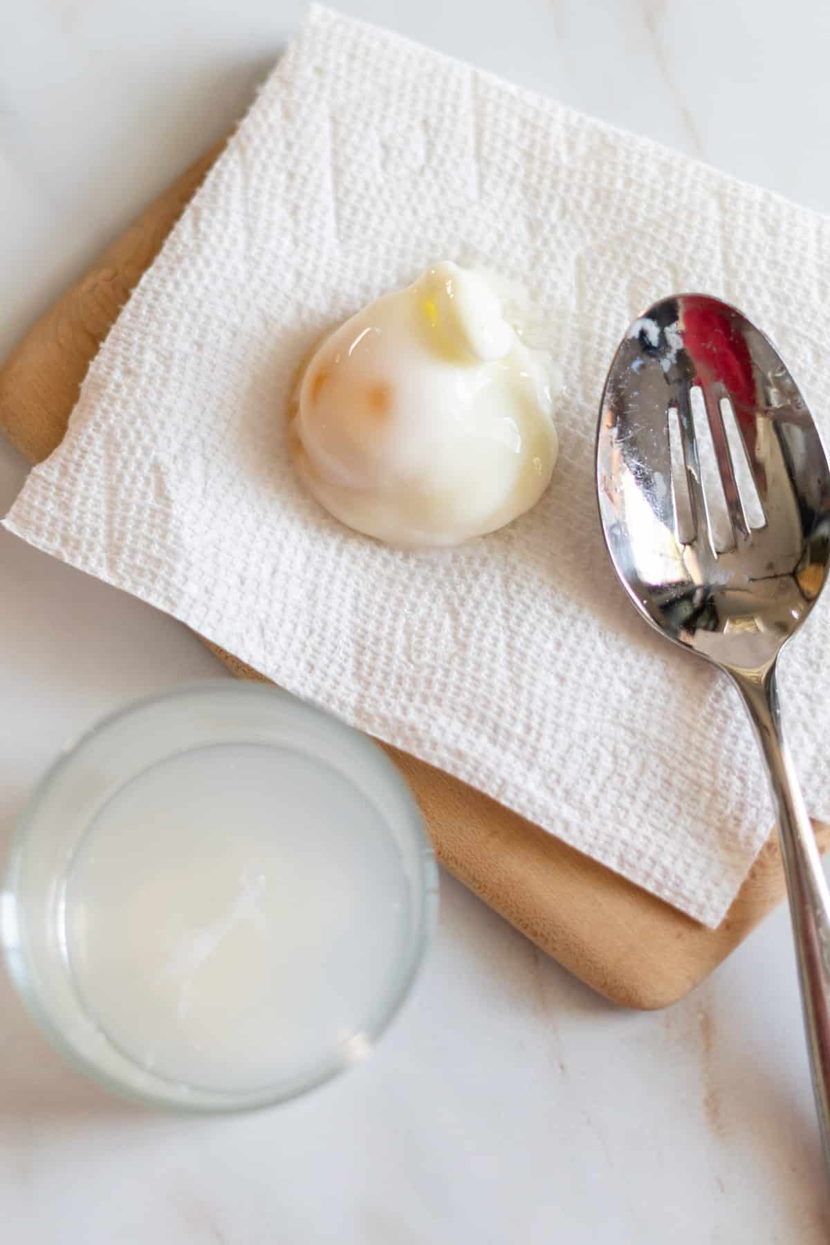 Poached egg draining on paper towel.