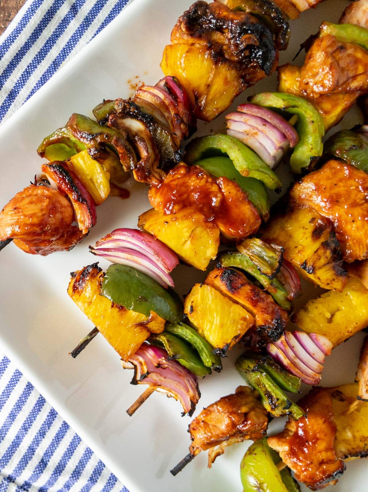 chicken and pineapple kabobs on a white plate.