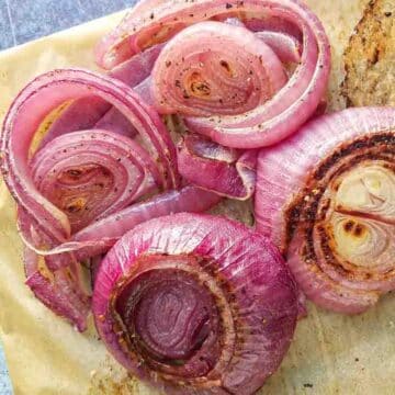 Roasted red onion on parchment paper.