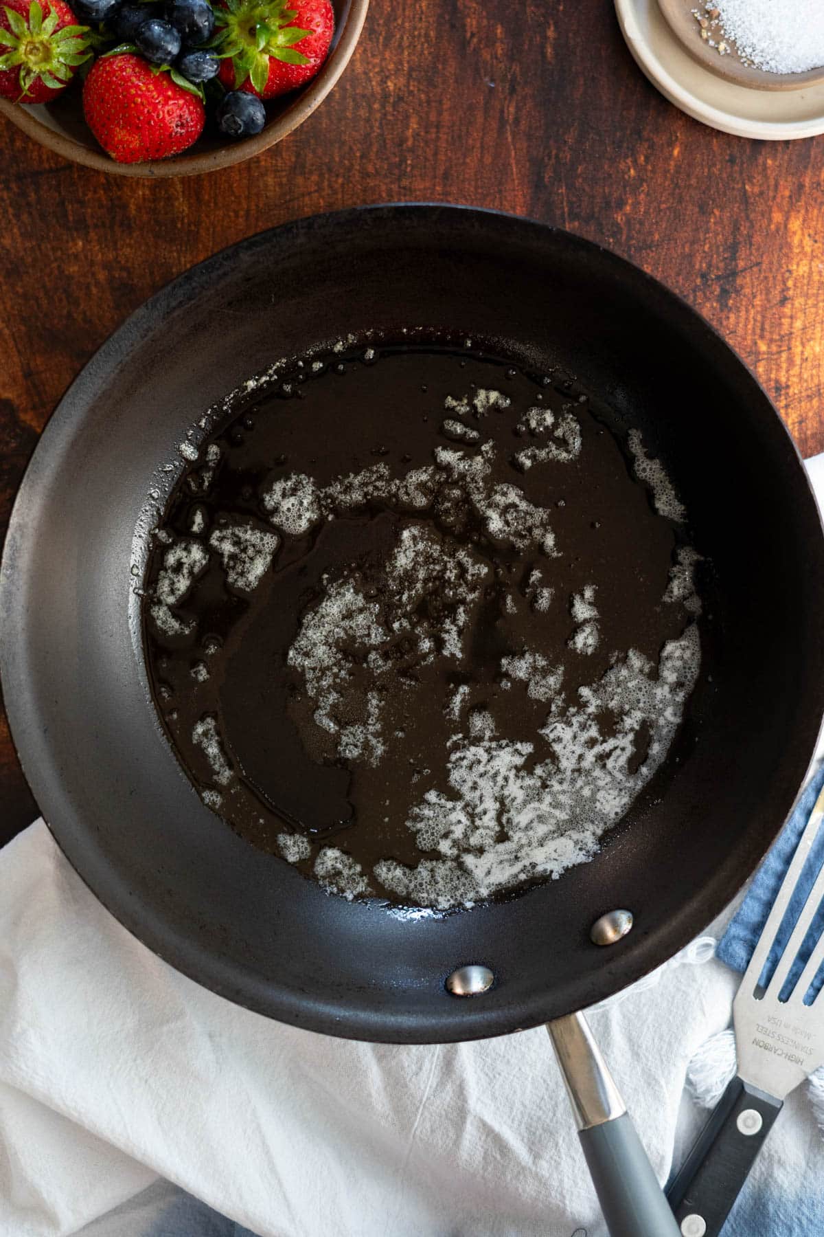 Melting butter in a non stick skillet.