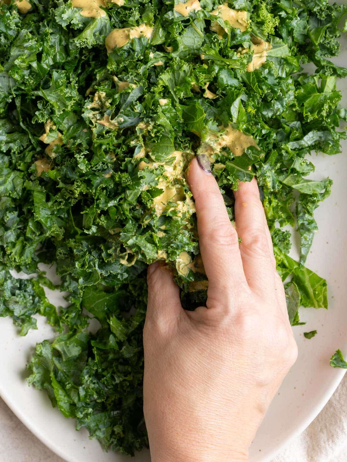 massaging dressing into the kale.