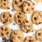 Chocolate chip cashew butter cookies on parchment paper.