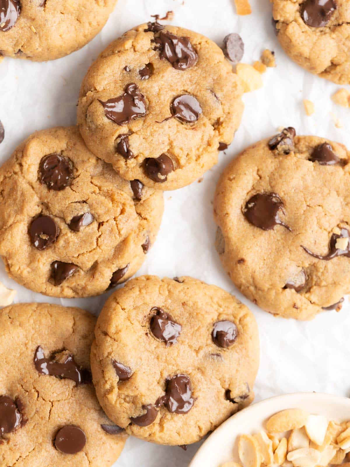 Chocolate chip cashew butter cookies on parchment paper.