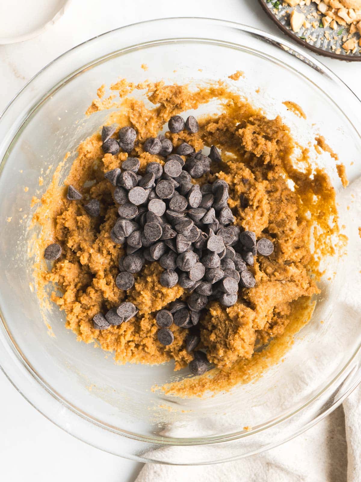 Adding chocolate chips to cookie dough.