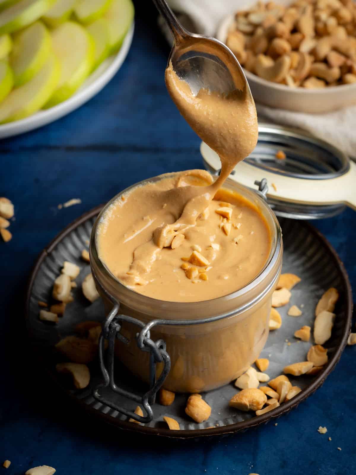Homemade cashew butter in a jar with a spoon.