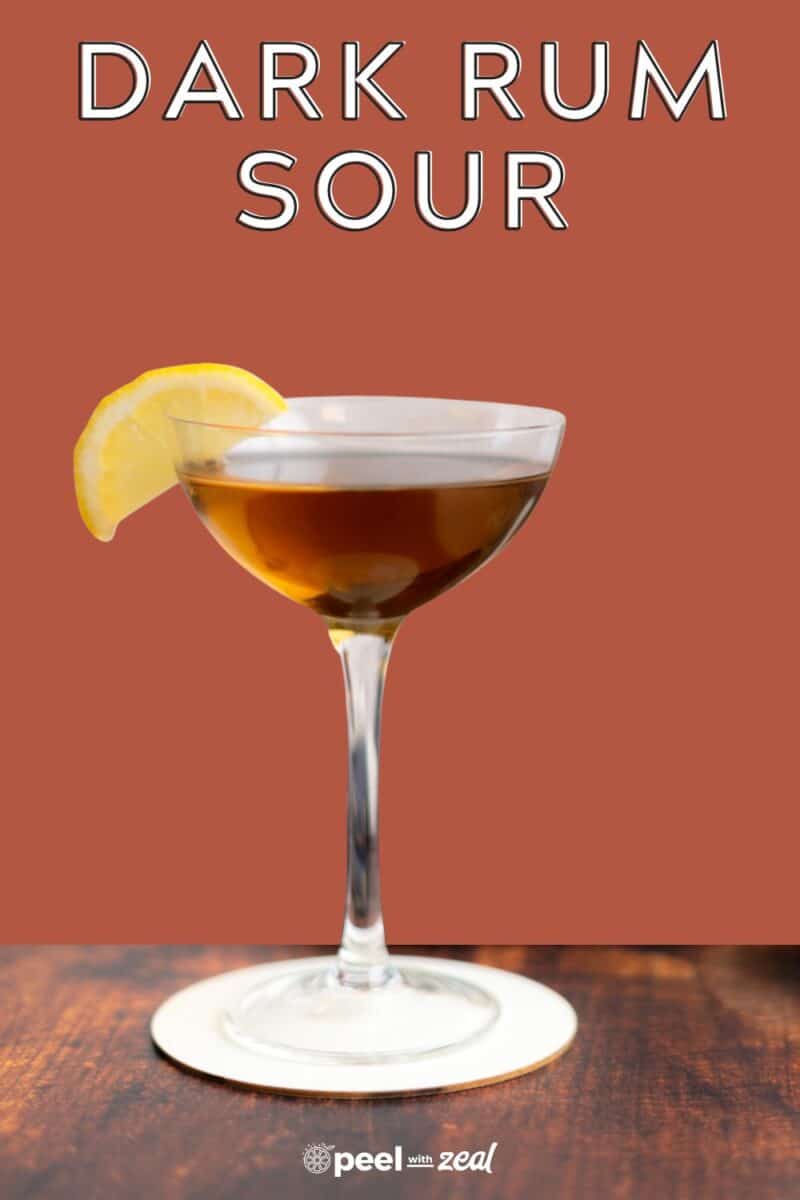 Rum cocktail in a coupe glass with a slice of lemon.