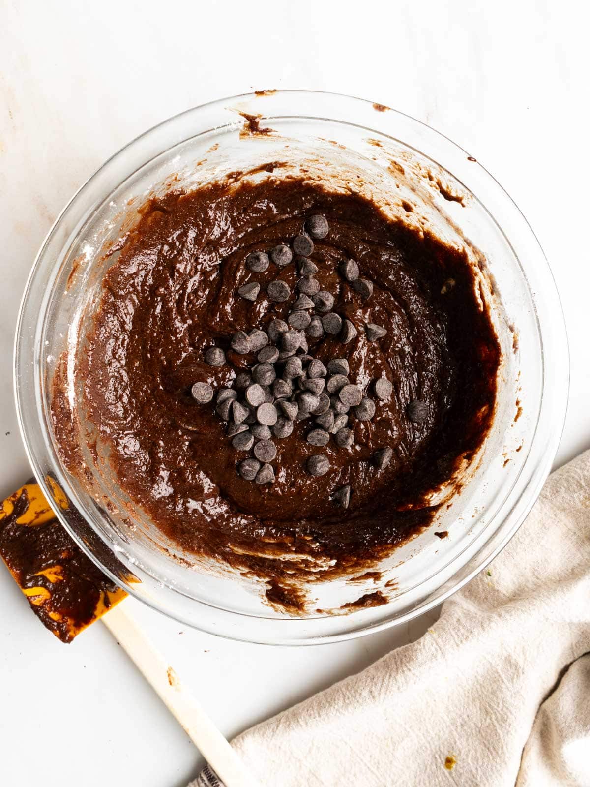 Adding chocolate chips to the brownie batter.