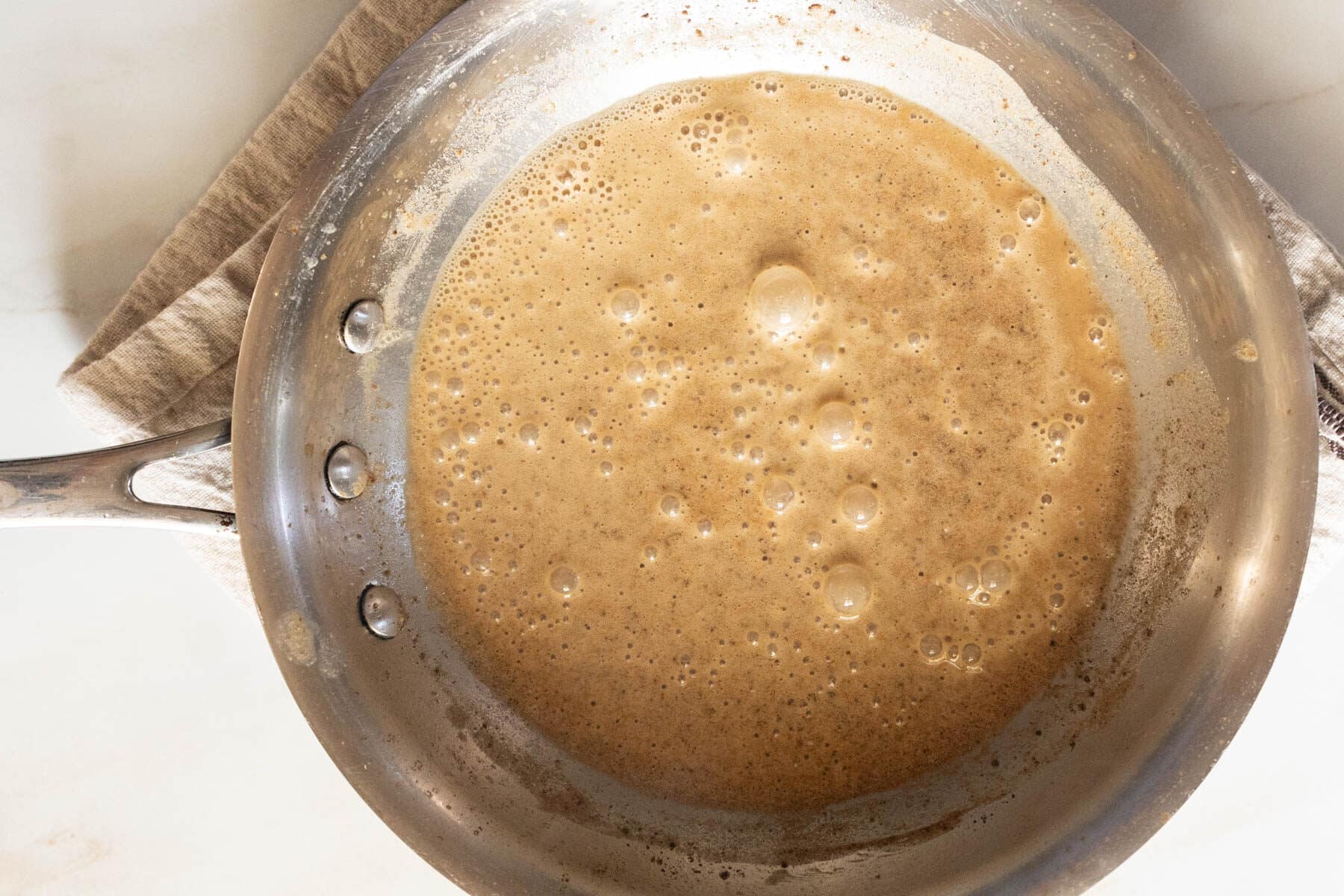 A pan on the countertop contains a peanut butter a gluten-free roux.