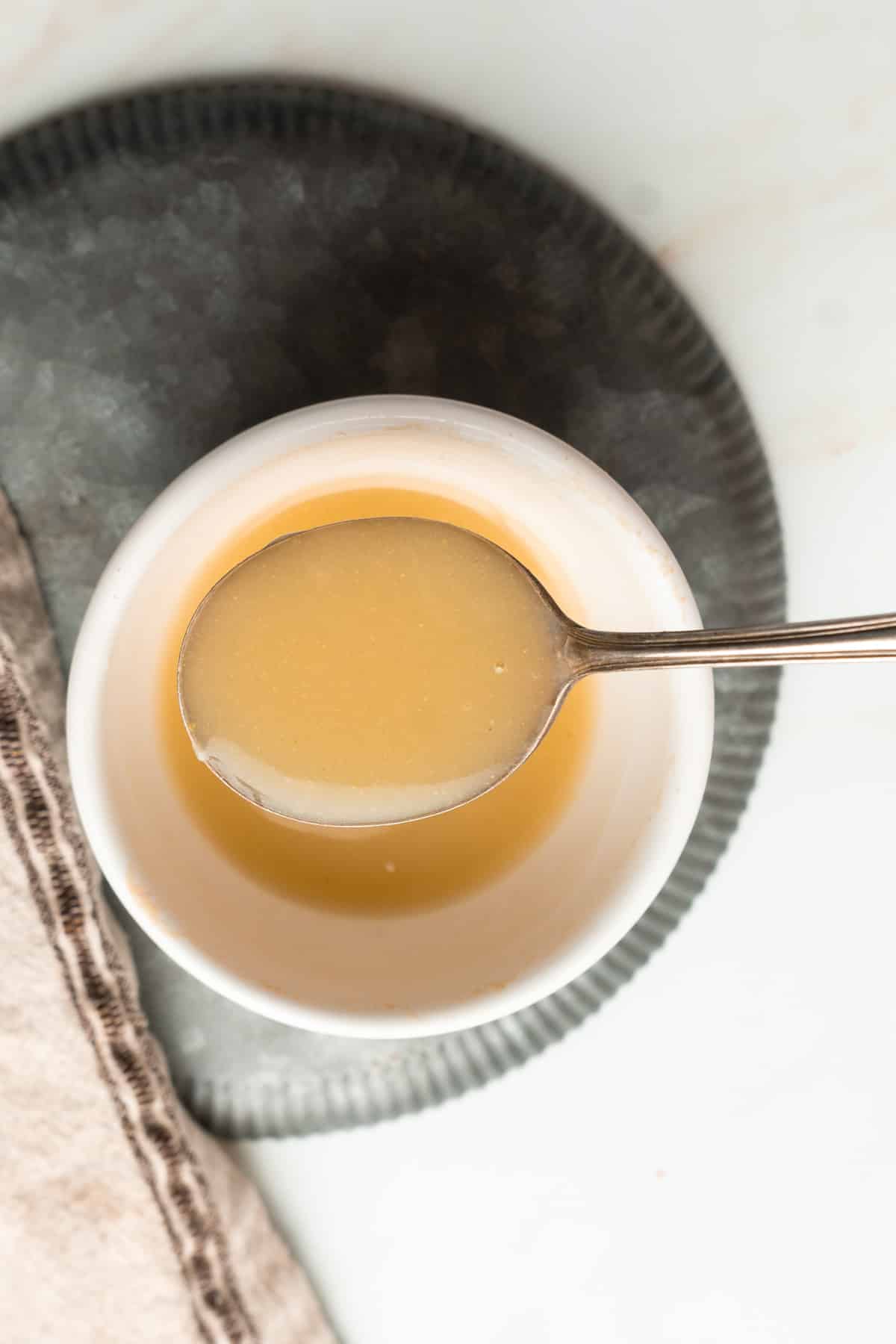 Gluten free pan sauce in a bowl with a spoon.