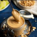 Spooning cashew butter into a jar.