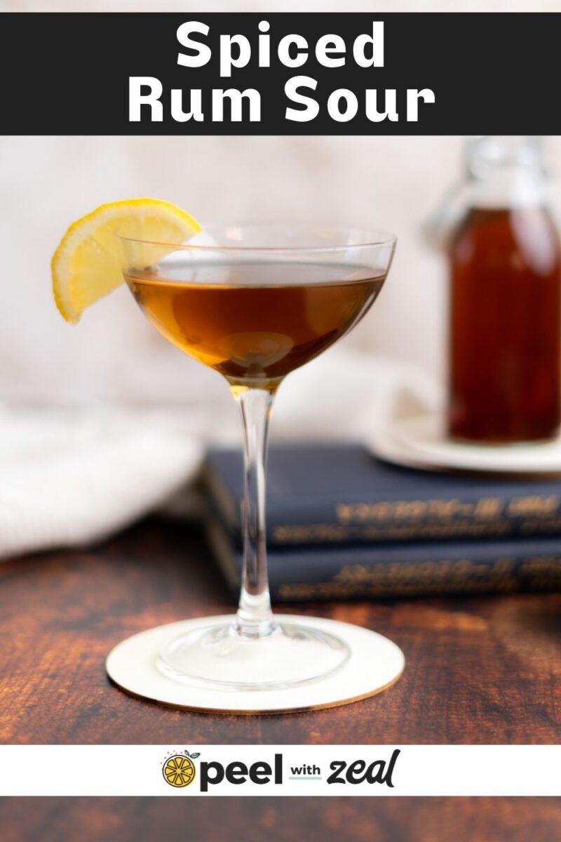 Rum cocktail in a coupe glass with a slice of lemon.