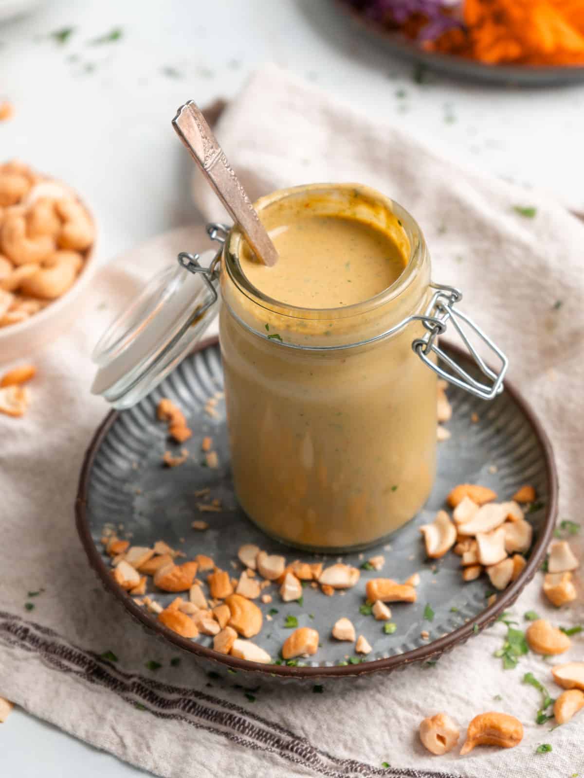 Spicy cashew dressing in a jar with a spoon.