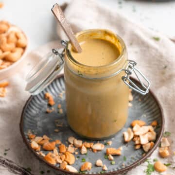 Spicy cashew dressing in a jar with a spoon.