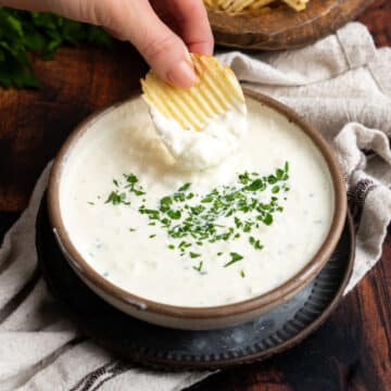 Dipping a potato chip into cream cheese onion dip.