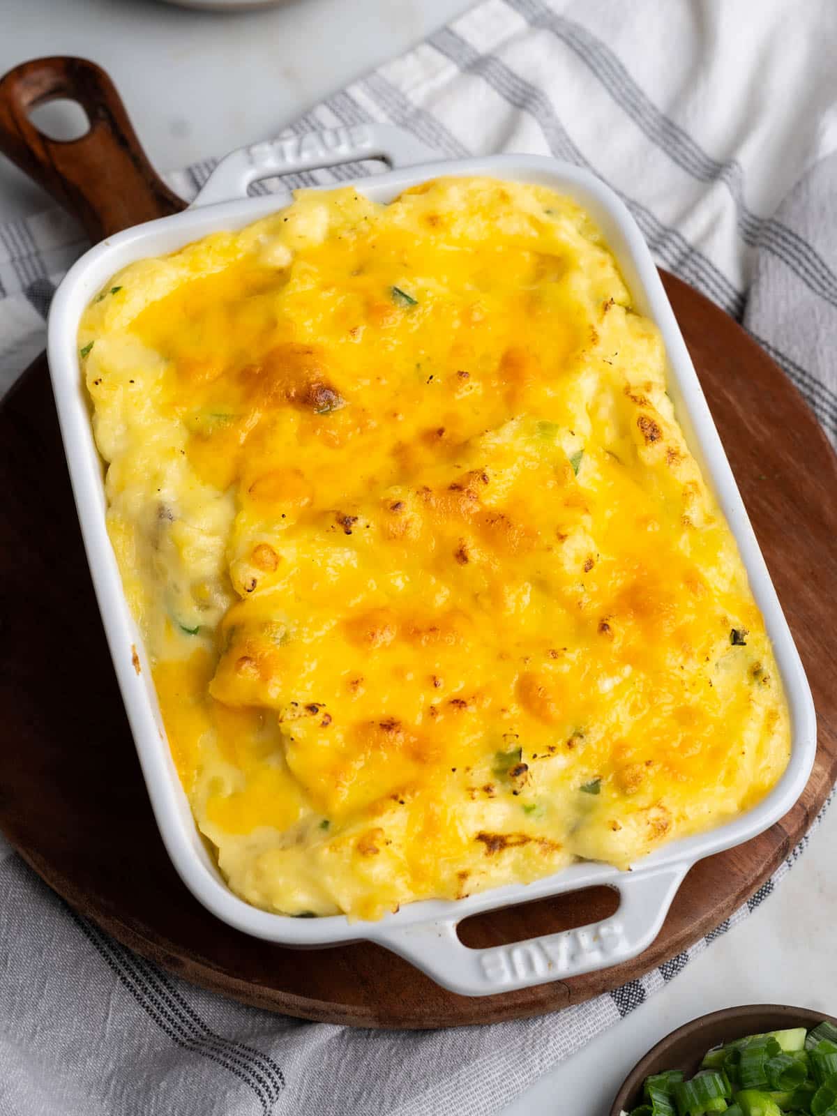 Baked cheesy mashed potatoes in a baking dish.