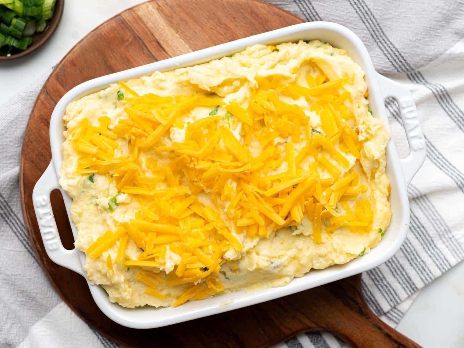 Mashed potatoes topped with cheese in a baking dish.