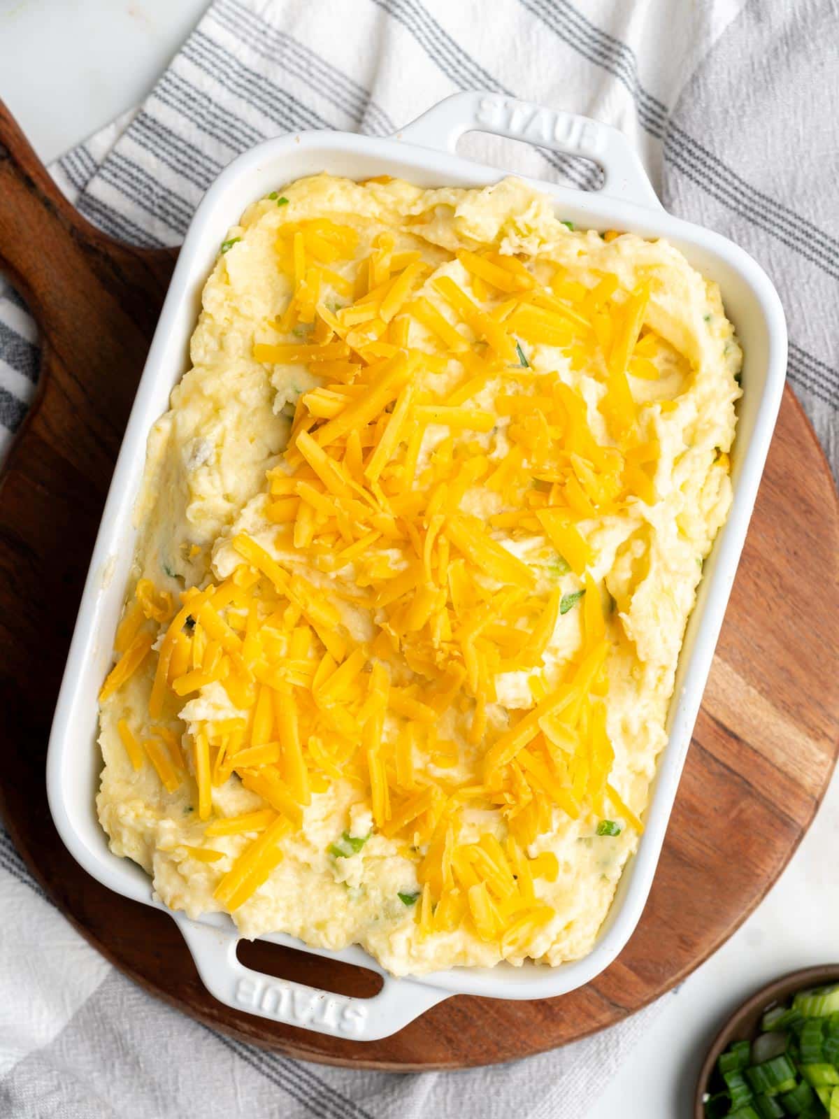 Mashed potatoes topped with cheese in a baking dish.