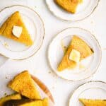 Slices of cornbread in a plate topped with butter.