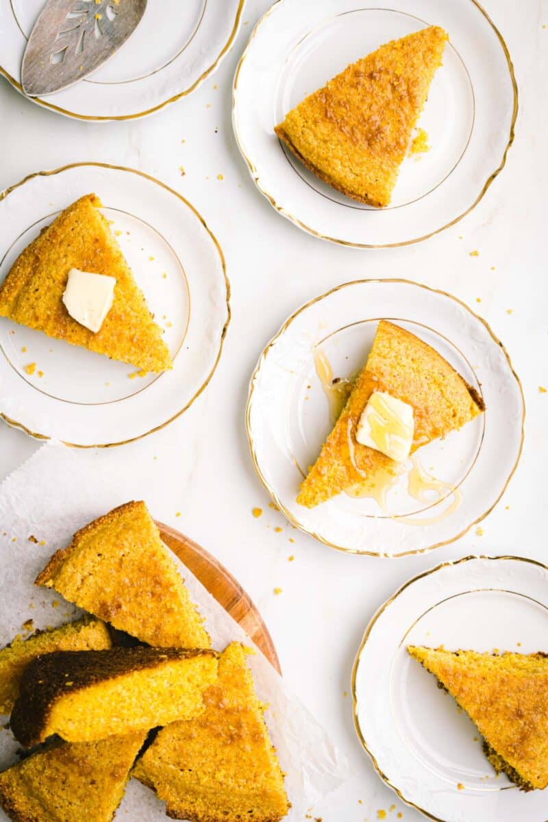 Slices of cornbread in a plate topped with butter.