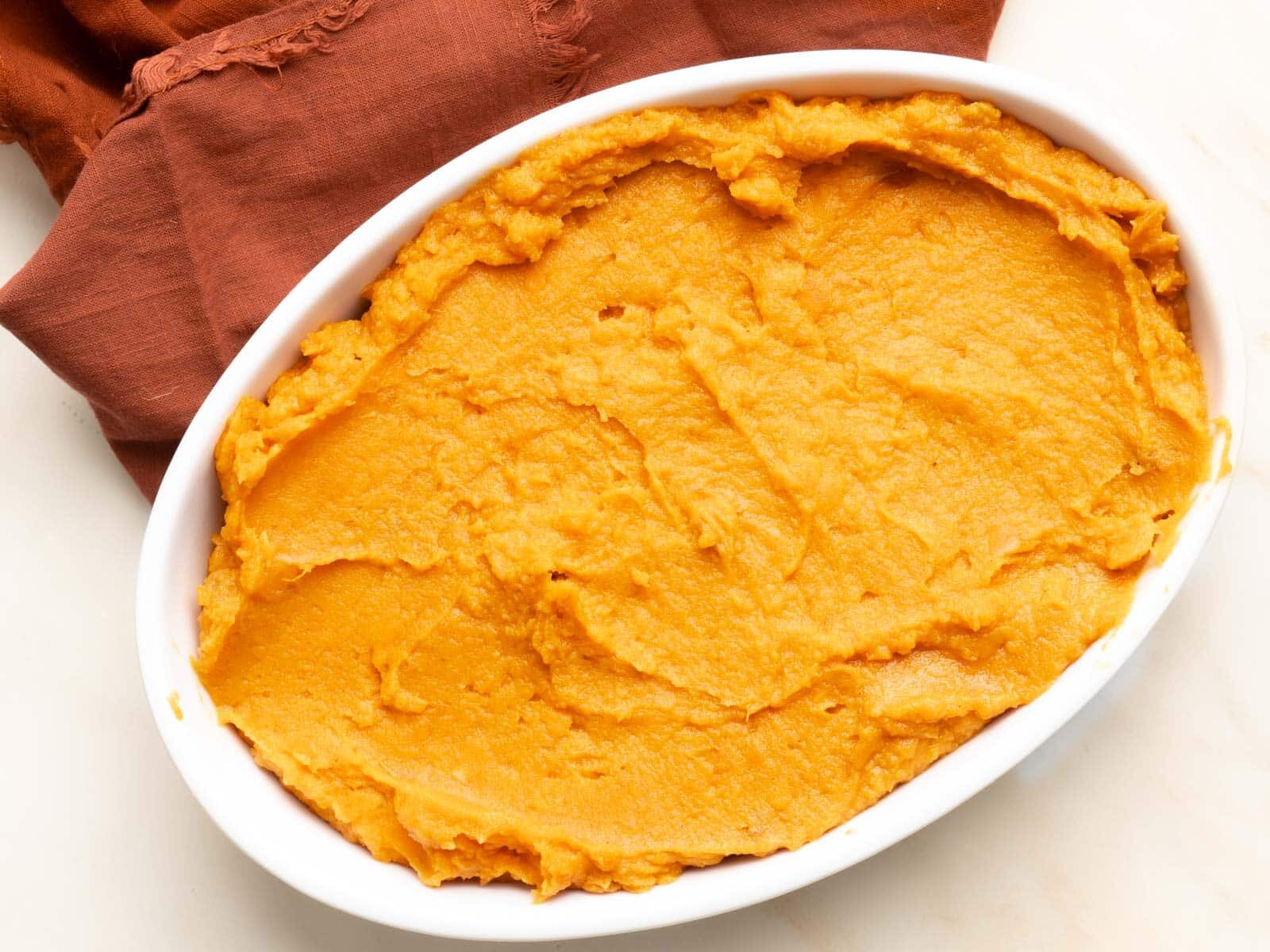 Sweet potato puree spread evenly in a baking dish.