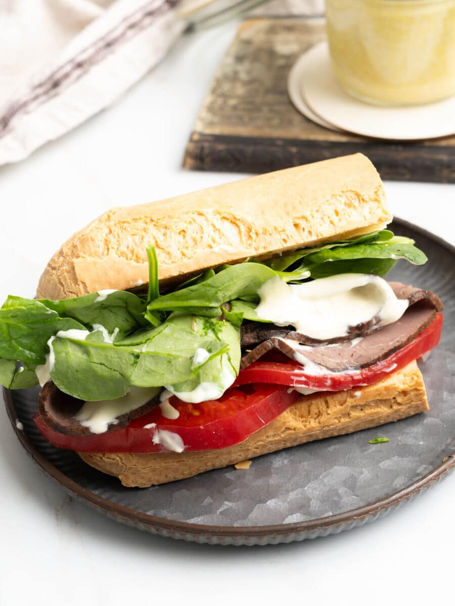 Roast beef sandwich with horseradish aioli on a plate.