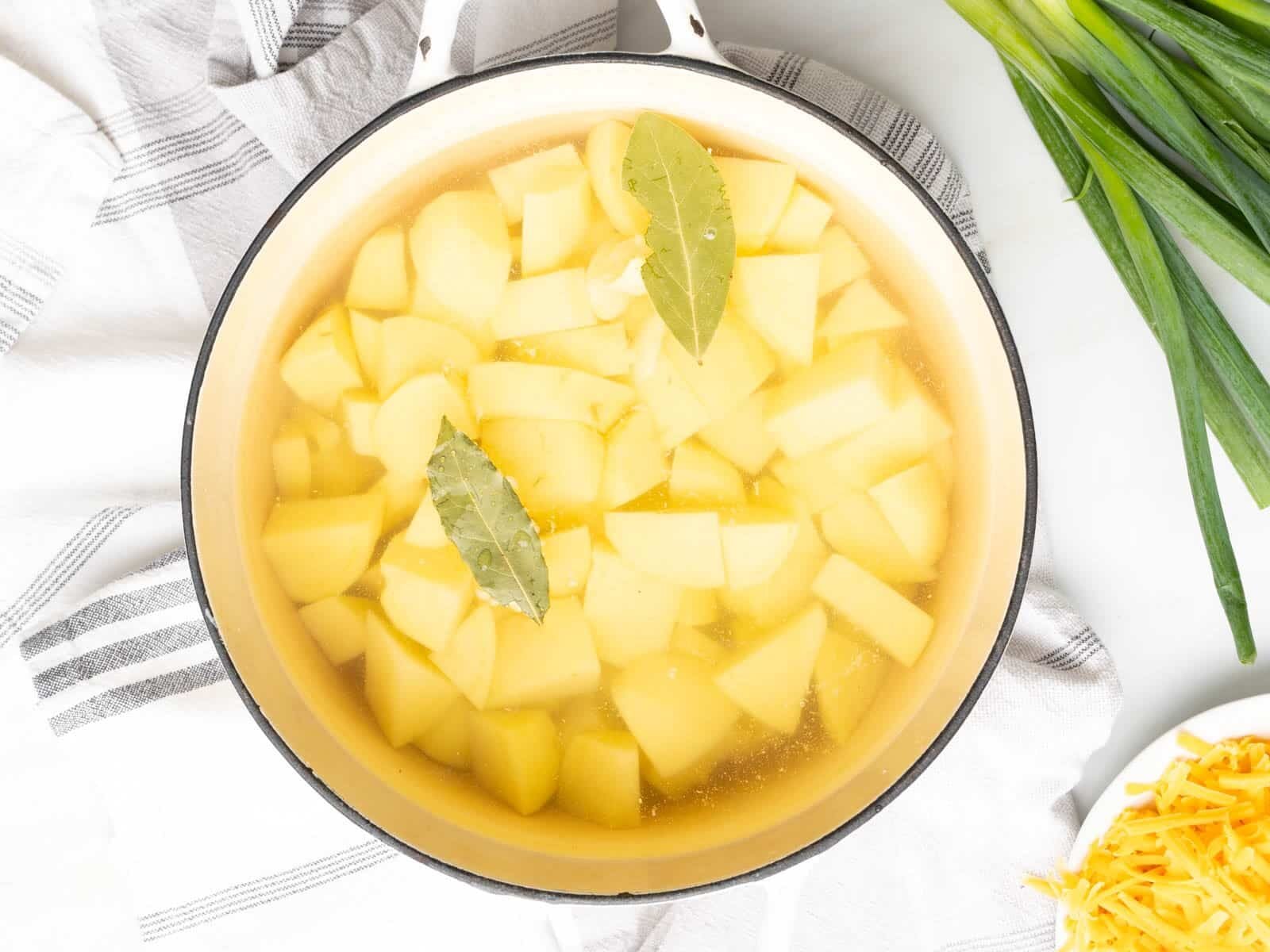 Potatoes soak in water with bay leaves.
