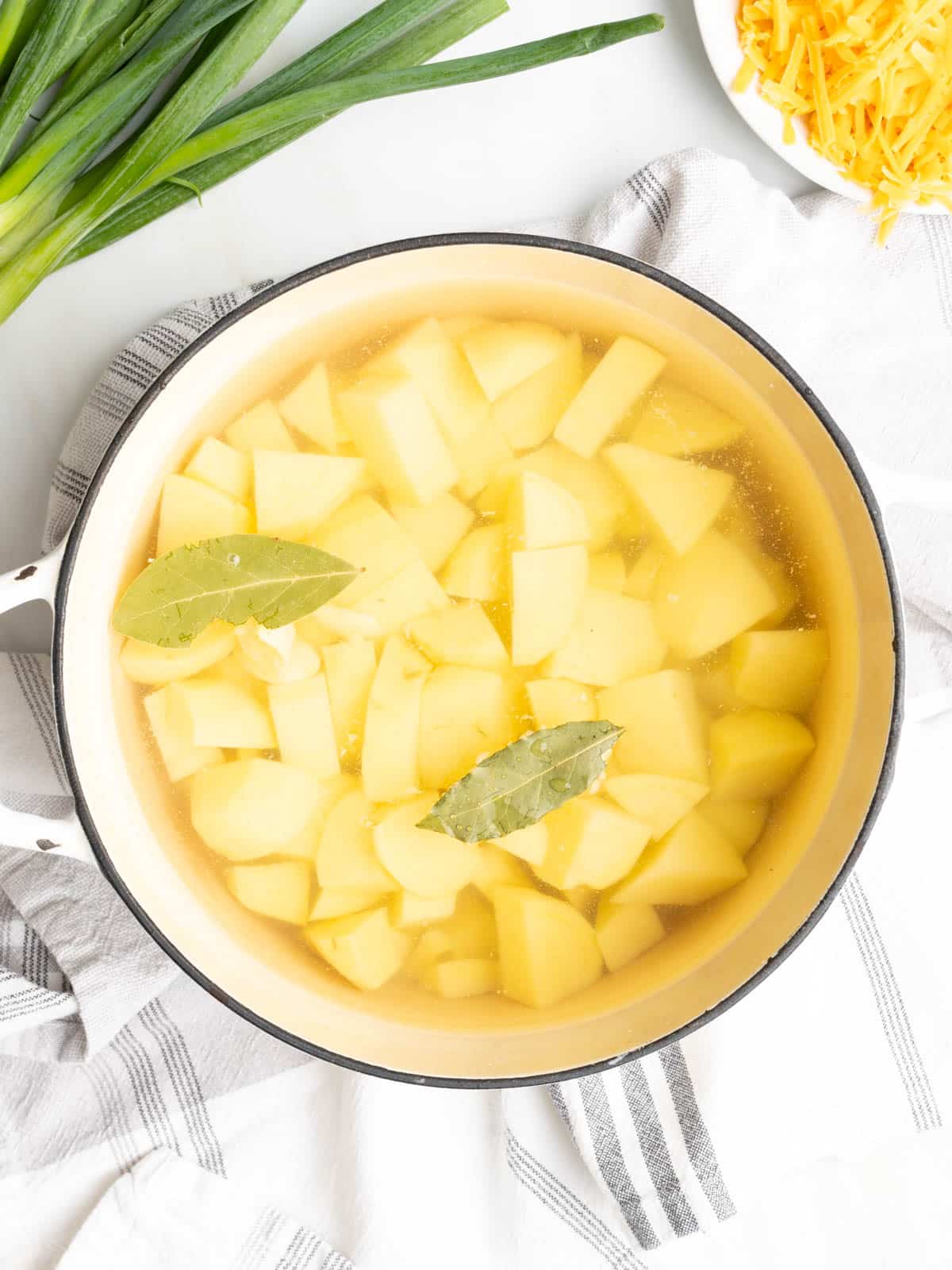 Potatoes soak in water with bay leaves.