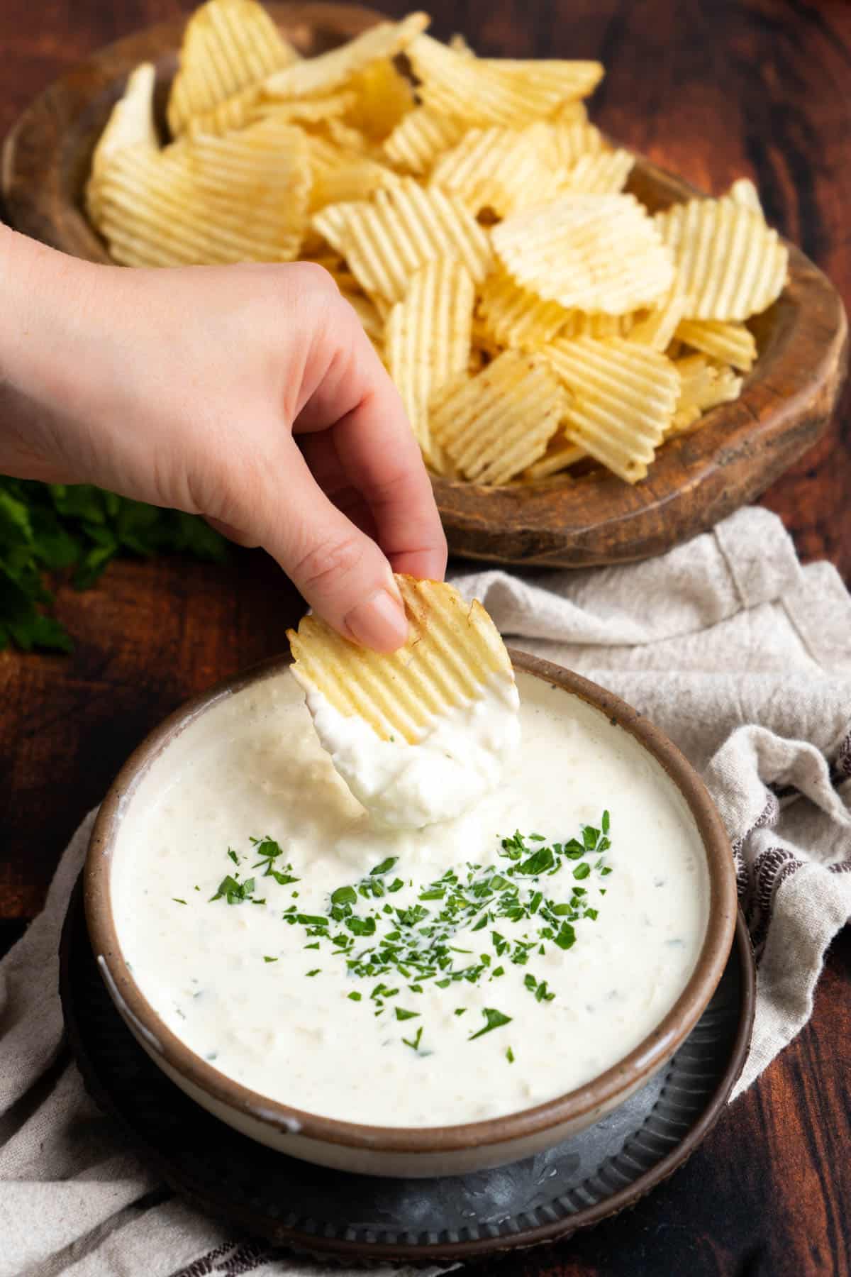 Dipping a potato chip into cream cheese onion dip.