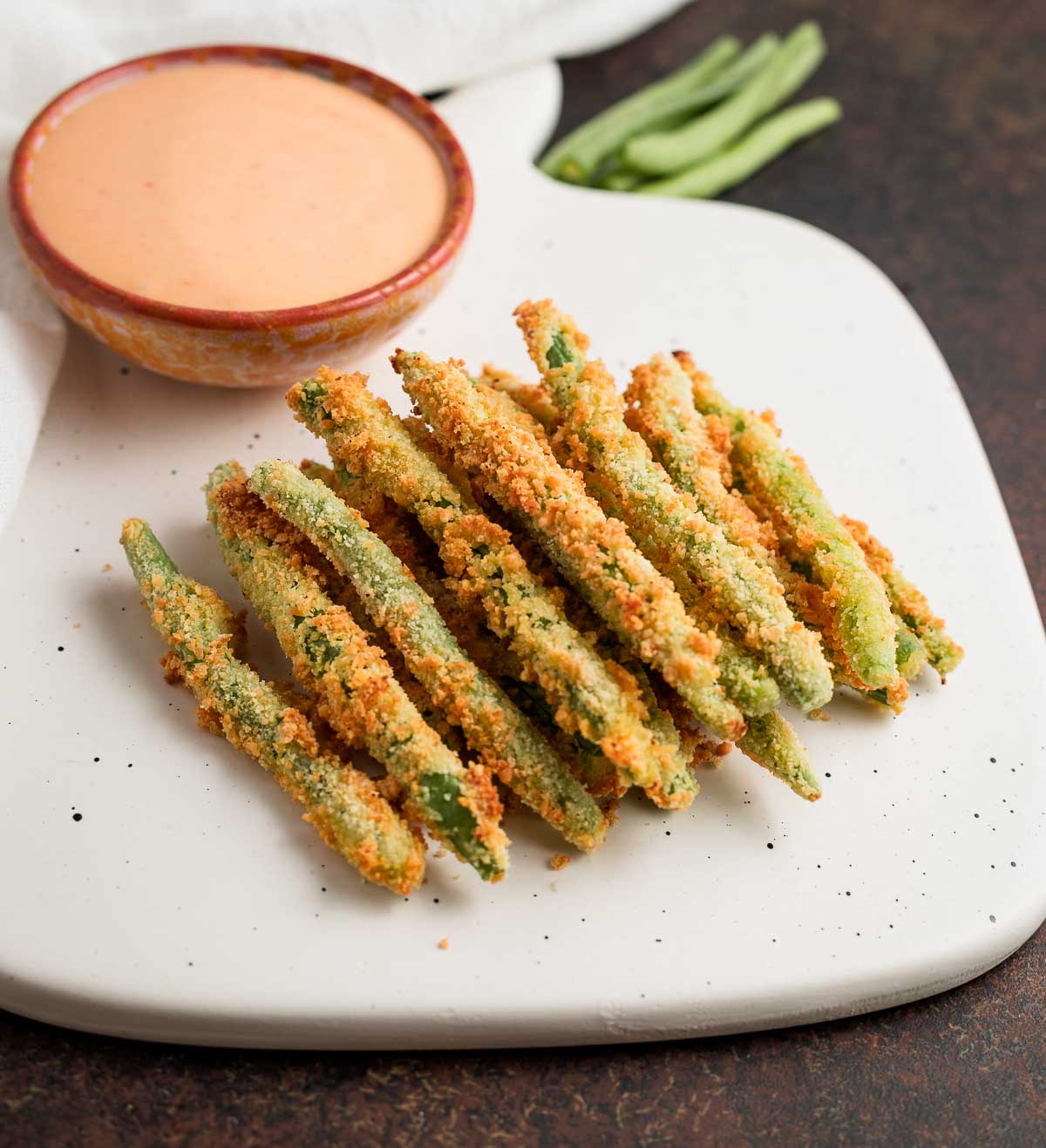 Air-fried green beans with a side of dipping sauce.