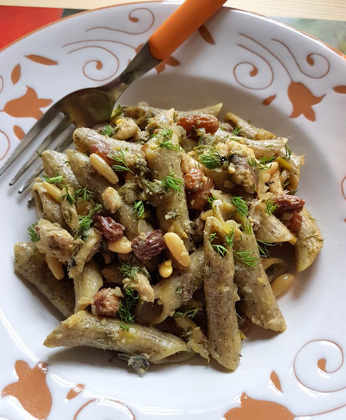 Sardine pasta on a plate with a fork.