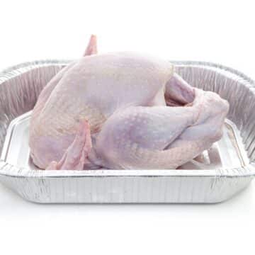 A thawed Thanksgiving turkey in a roasting pan.