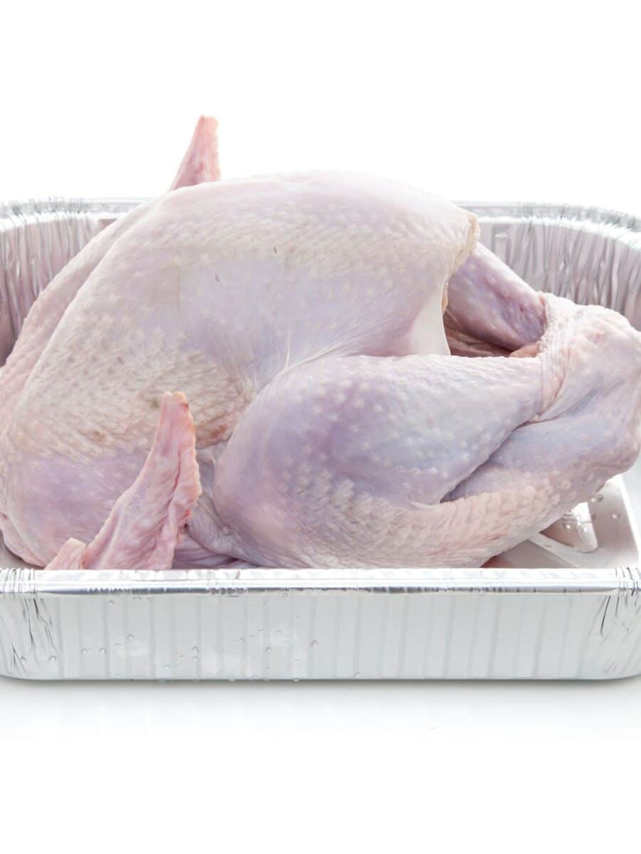 A thawed Thanksgiving turkey in a roasting pan.