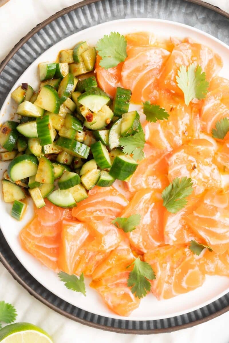 Salmon Crudo with a side of spicy cucumber slices.