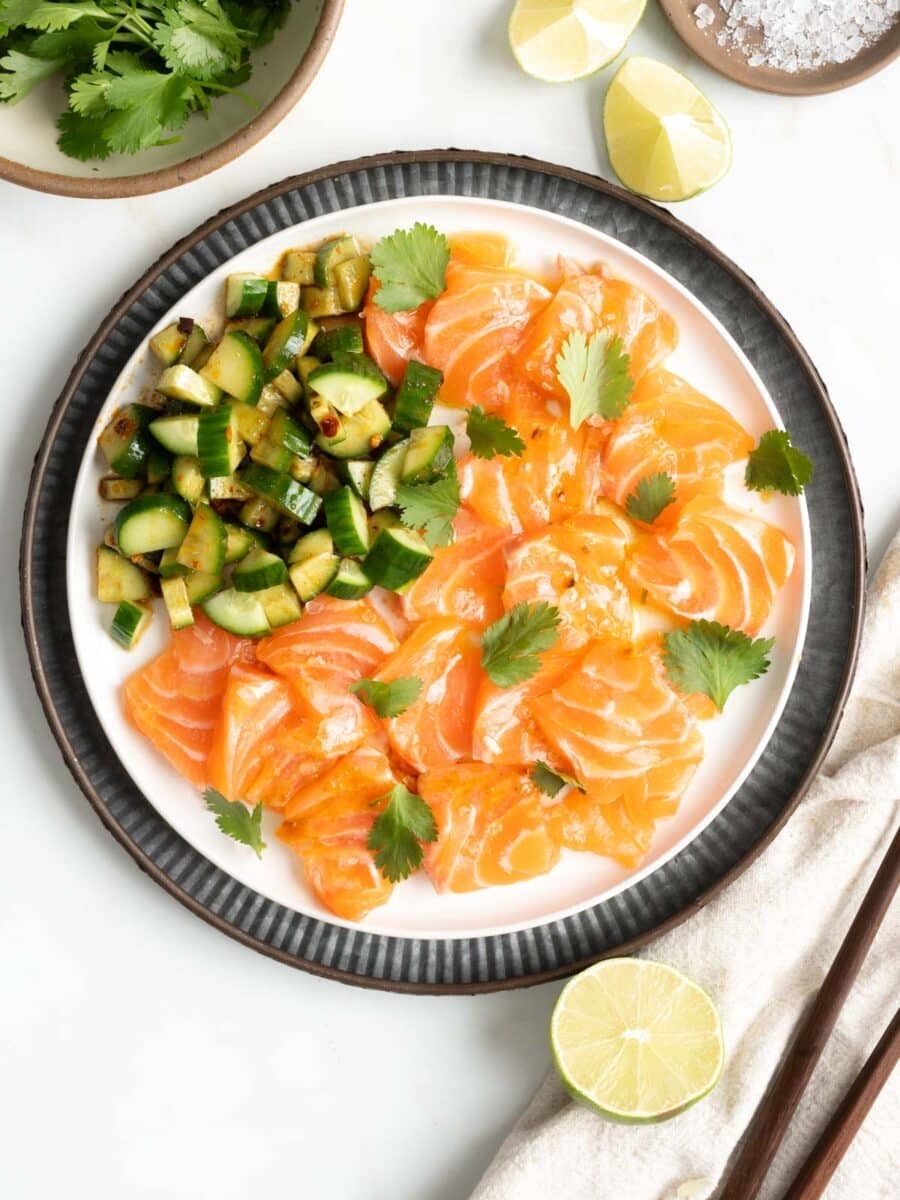 Salmon Crudo with a side of spicy cucumber slices.