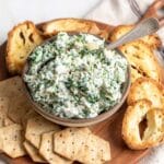 Spinach artichoke dip in a bowl with a spoon.