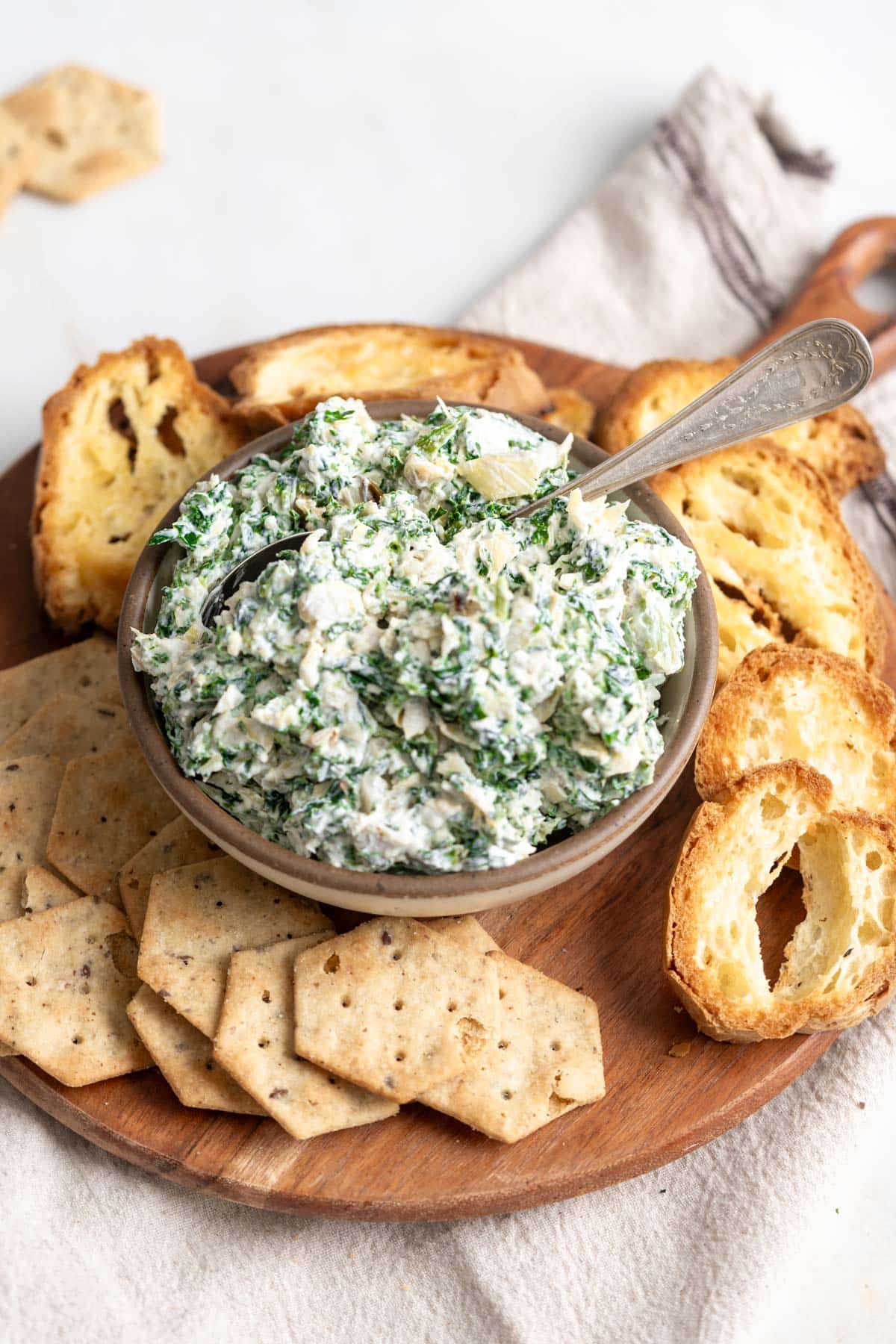 Spinach artichoke dip in a bowl with a spoon.