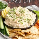 Cold Cajun crab dip in a bowl with sides of vegetables and crackers.