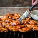 Chicken parts brushed with barbecue sauce.