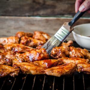 Chicken parts brushed with barbecue sauce.