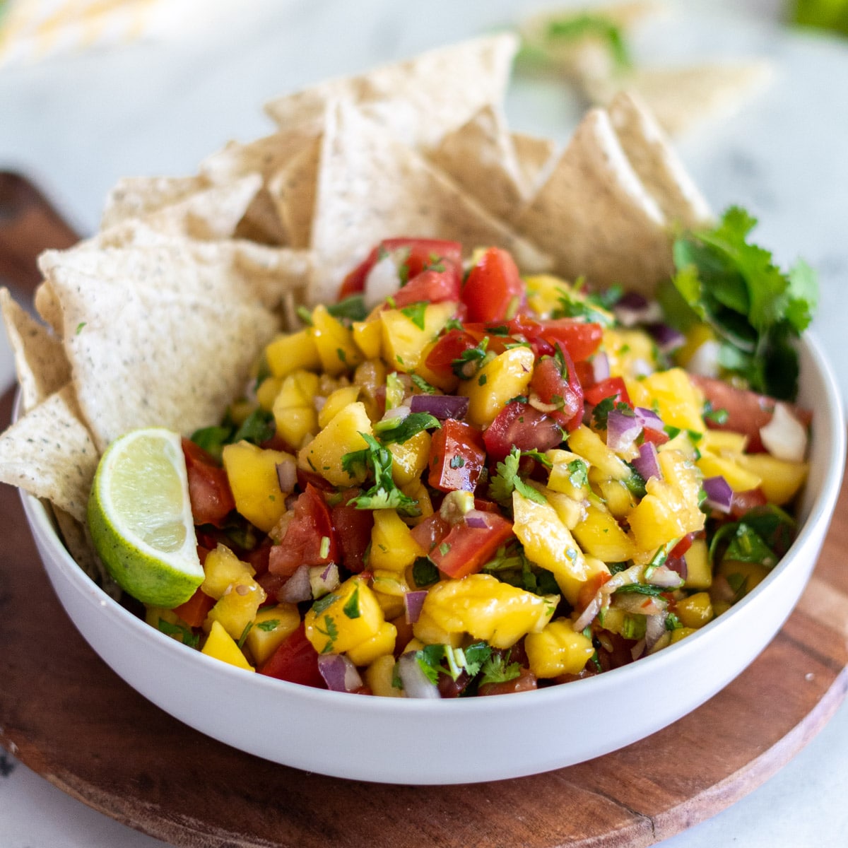 Mango pico in a bowl with tortilla chips. 