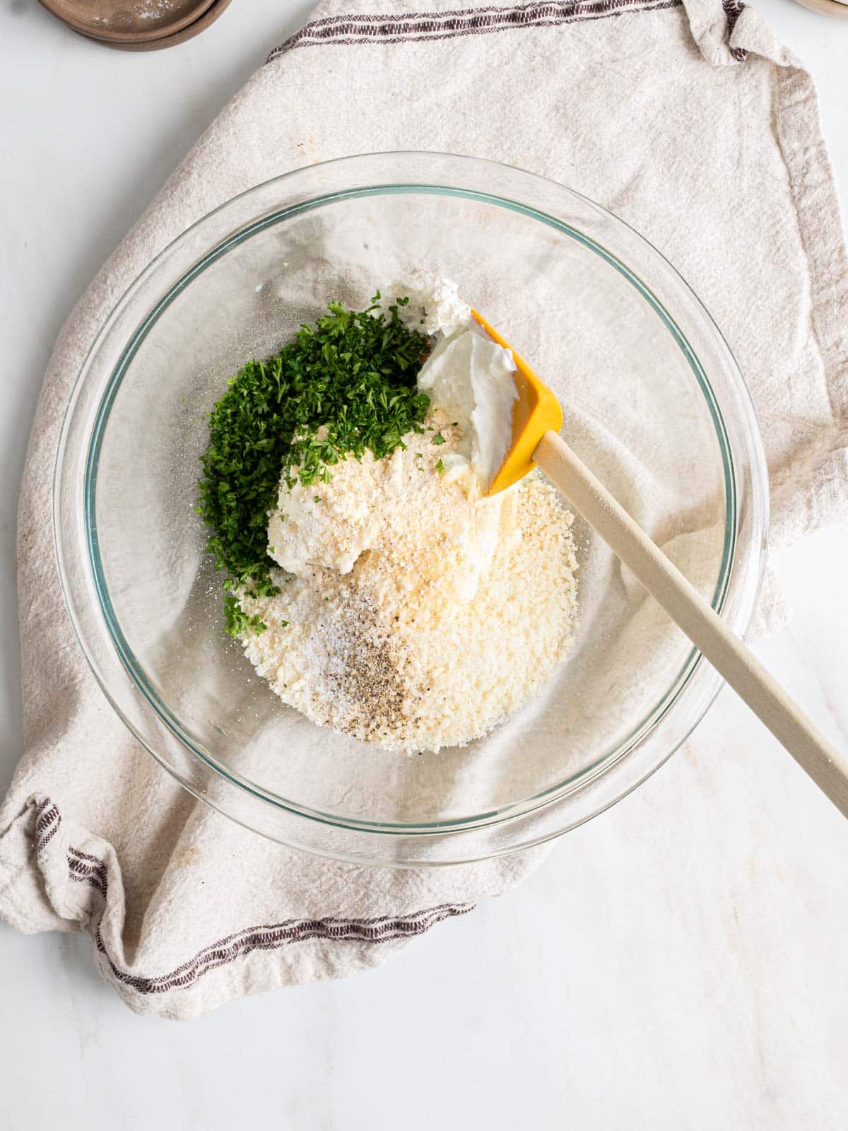 Spinach artichoke dip ingredients in a bowl with a spatula.