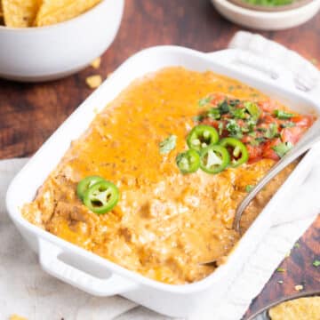 Cheese dip with beef in a dish with a silver spoon.