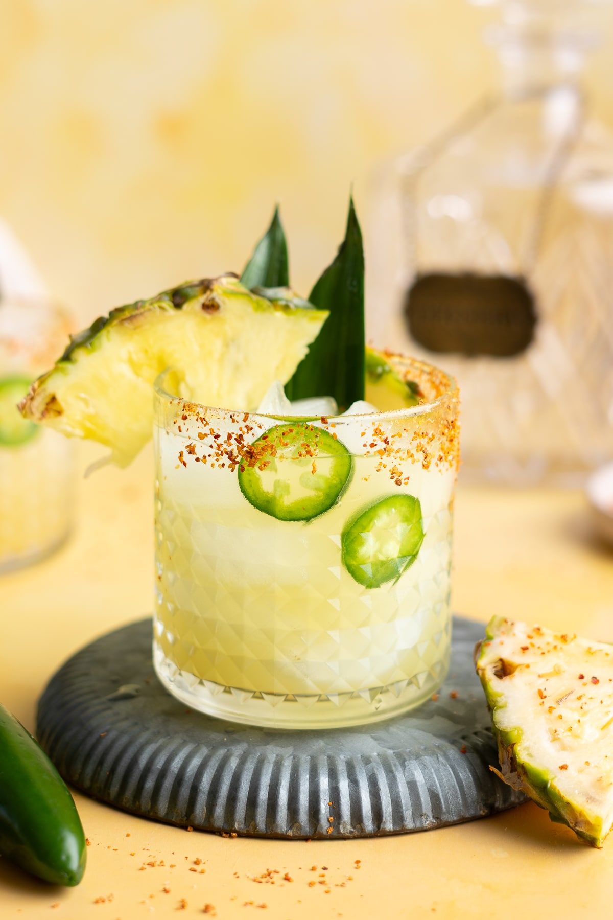 A glass of pineapple margarita with a slice of pineapple.