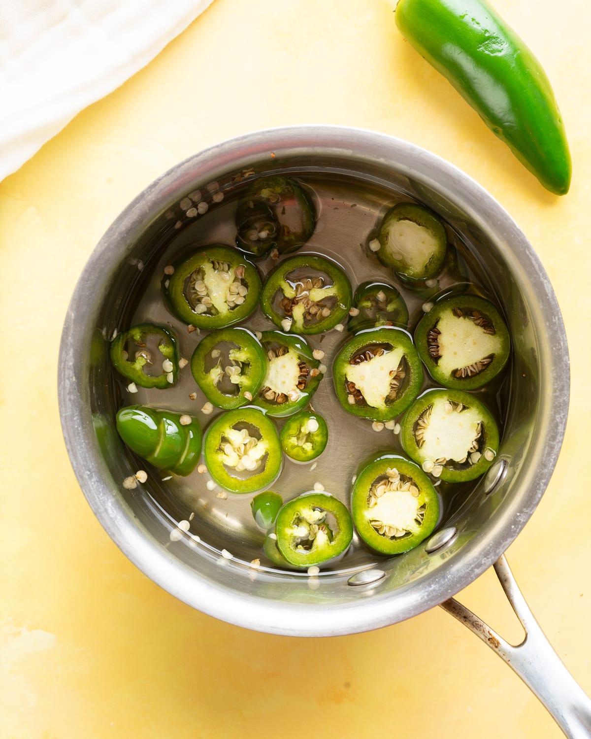 Jalapeno slices in a pot.