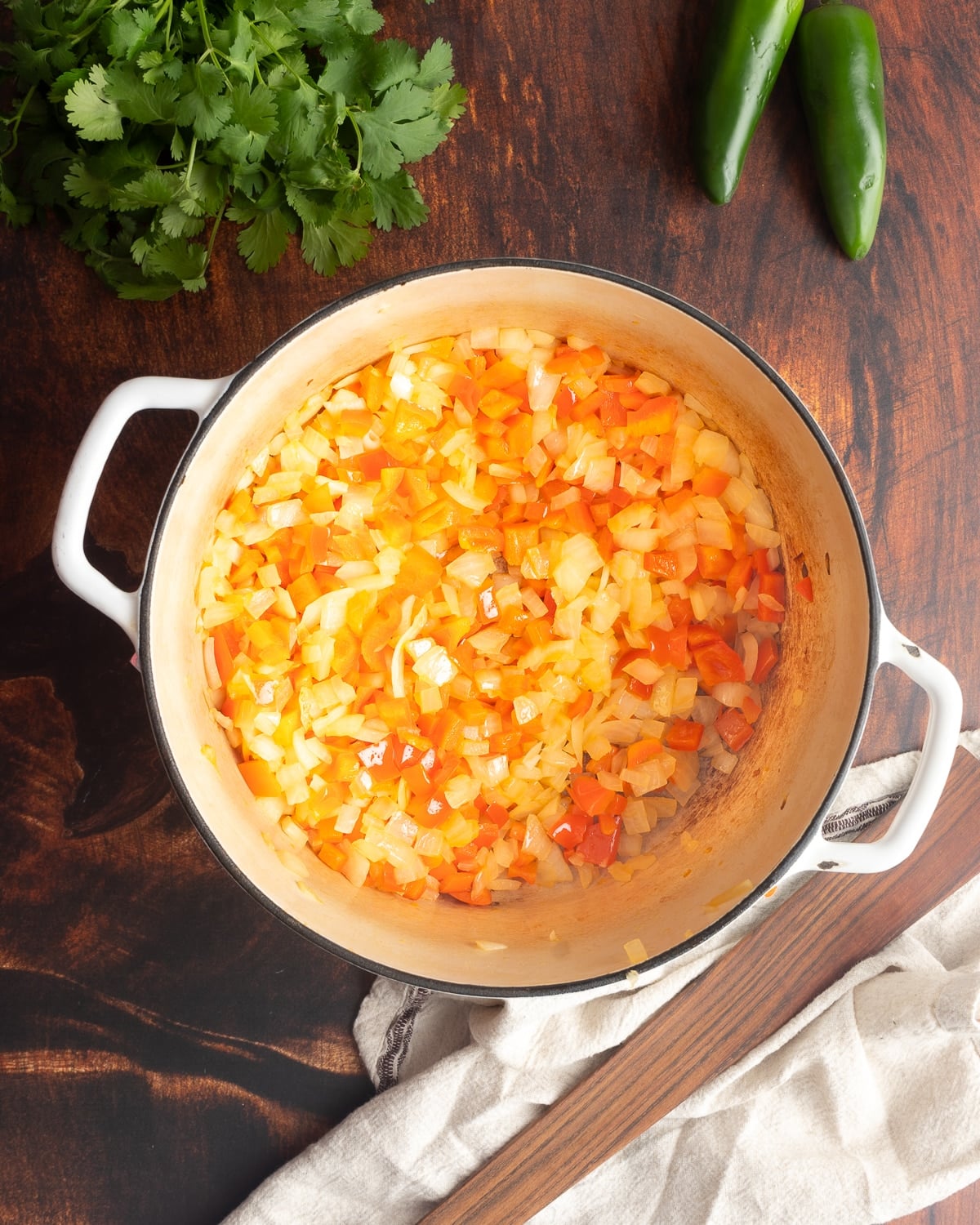 Sautéed onion and peppers in a pot.