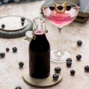 Blueberry syrup in a glass bottle with a lid.