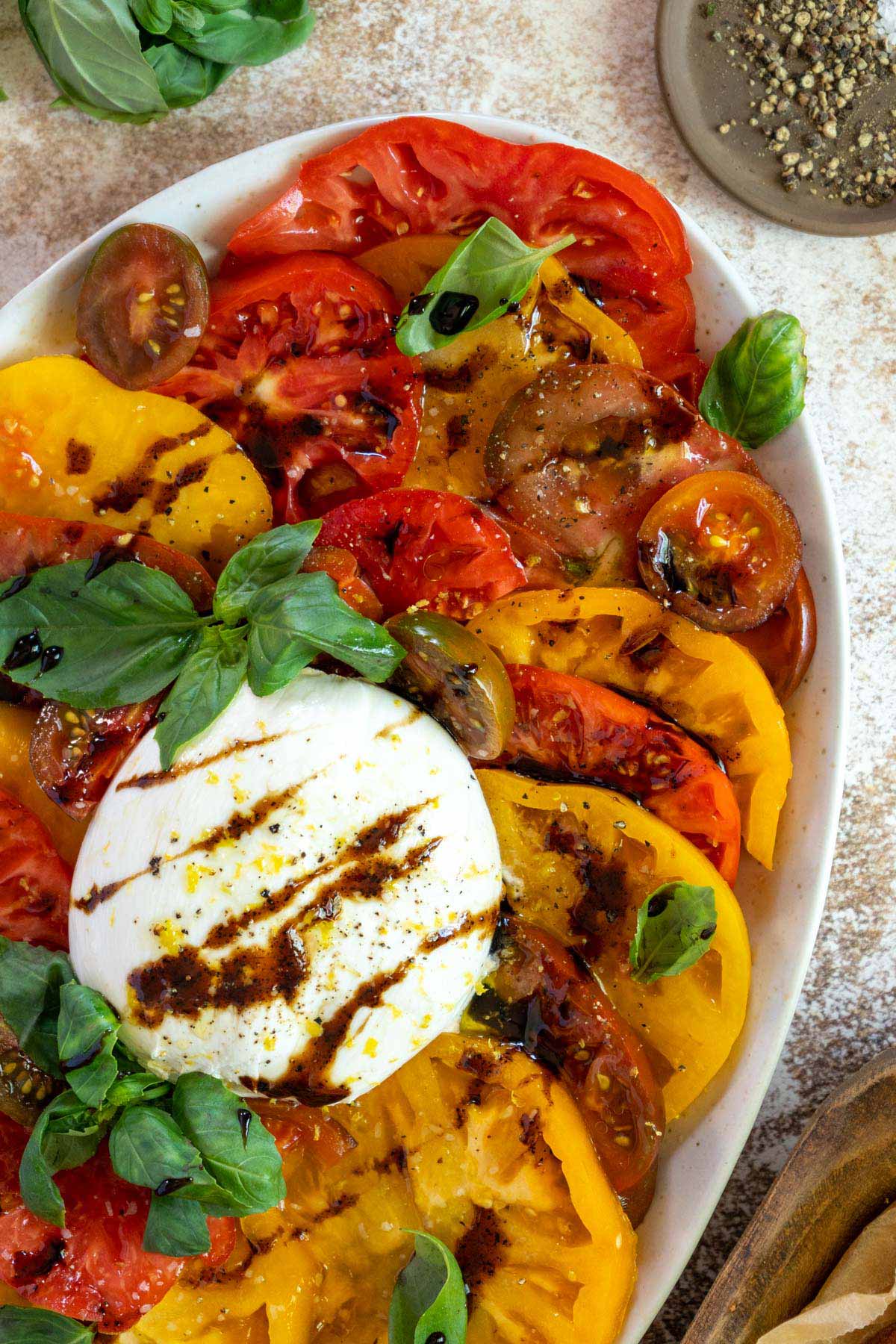 Burrata caprese salad on a platter.